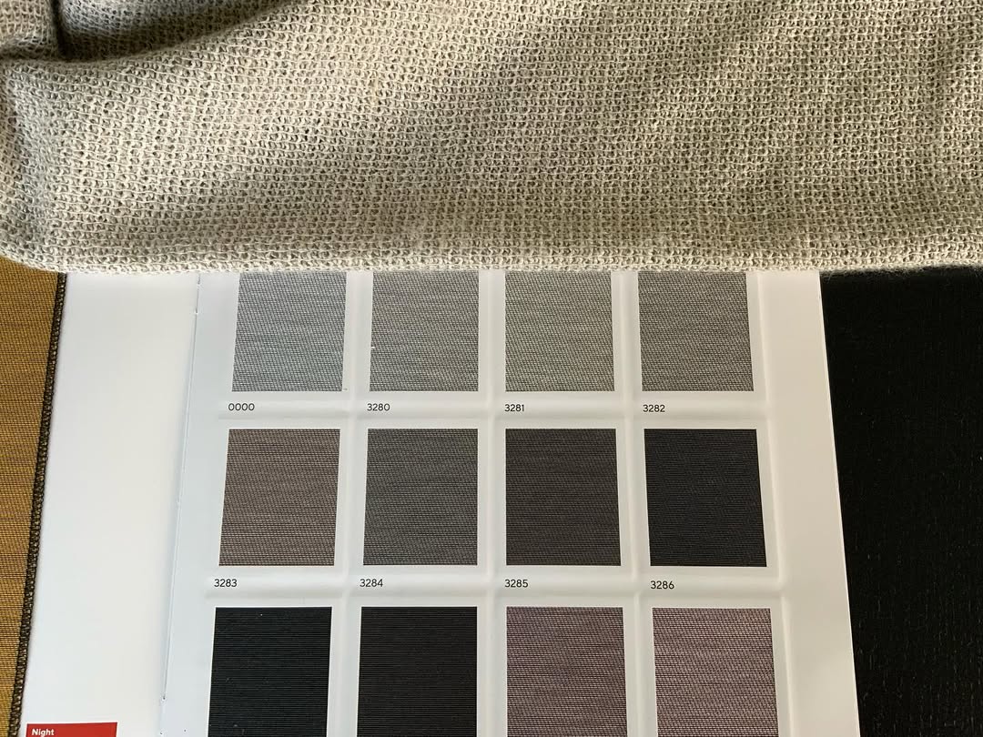 Stalenboek met kleurstalen en stofdetail tijdens advies aan huis